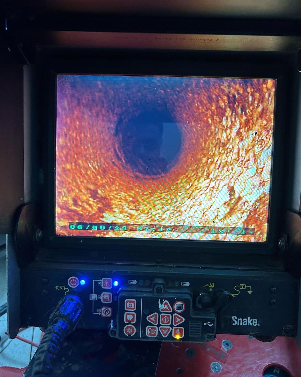Inspection camera monitor displaying a close-up view of a pipe's interior surface.